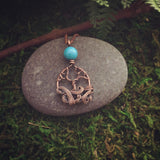 Mini swirling tree necklace with turquoise colored accent